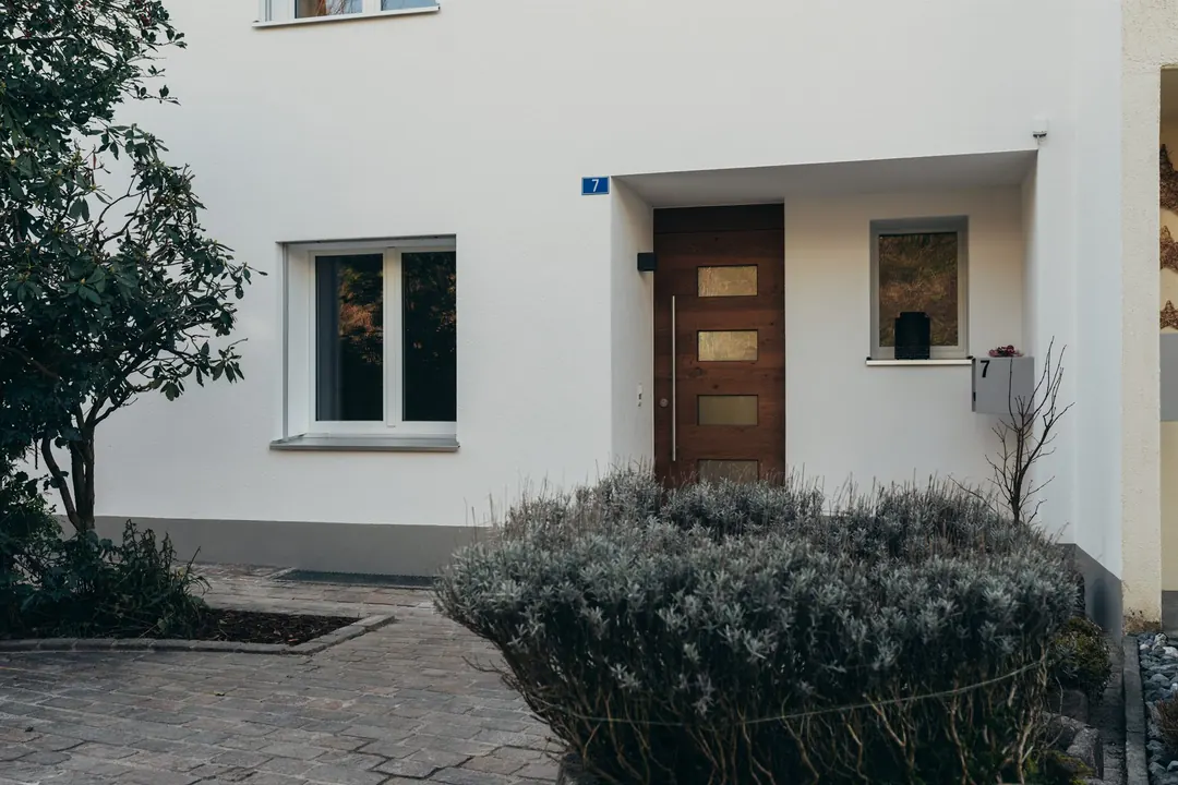 Renovierter Hauseingang mit Holztüre und Lavendelbeet